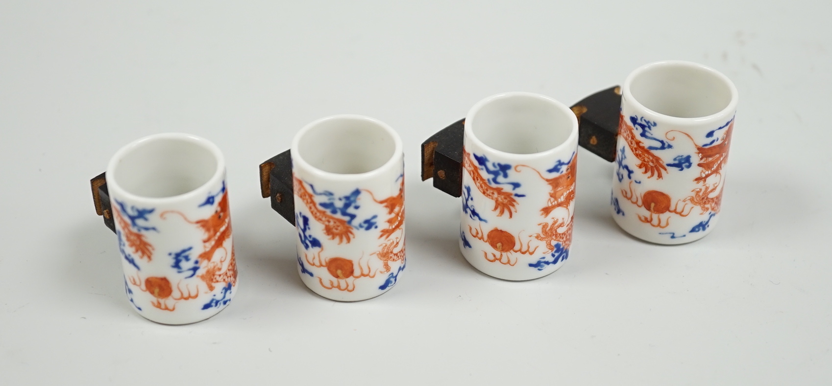 A set of four Chinese enamelled porcelain 'dragon' bird feeders, late 19th / early 20th century, 3.5cm high